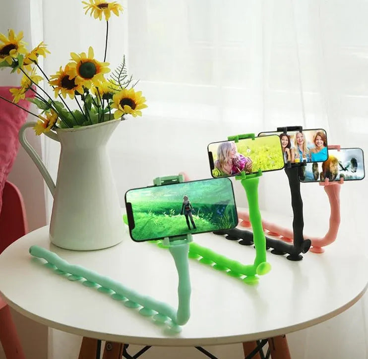 Black flexible lazy bracket mobile phone holder with long arm and suction cup base on a desktop