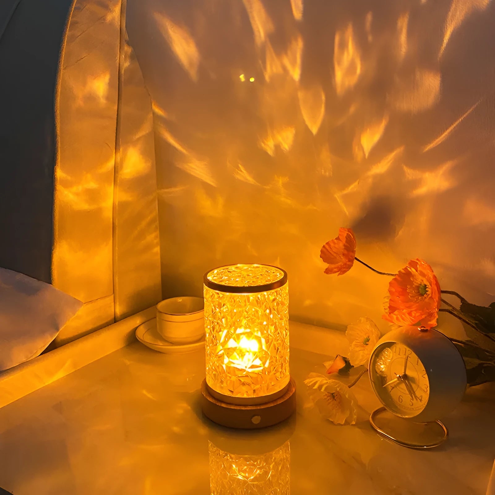 Small rotating water ripple night light with a solid wood base and acrylic body on a bedside table.