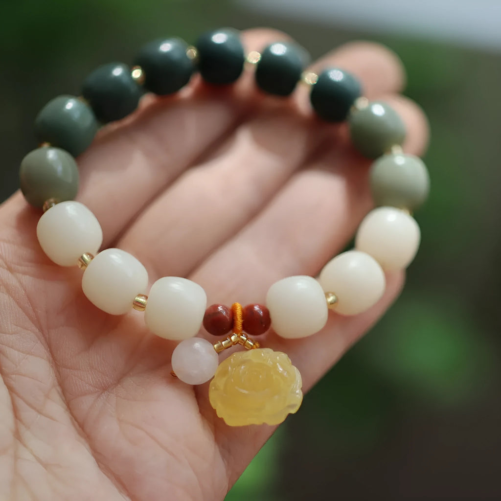 Close-up of a 10mm floral bracelet made from woven Bodhi root with gradient white jade and a natural beeswax lotus bead.