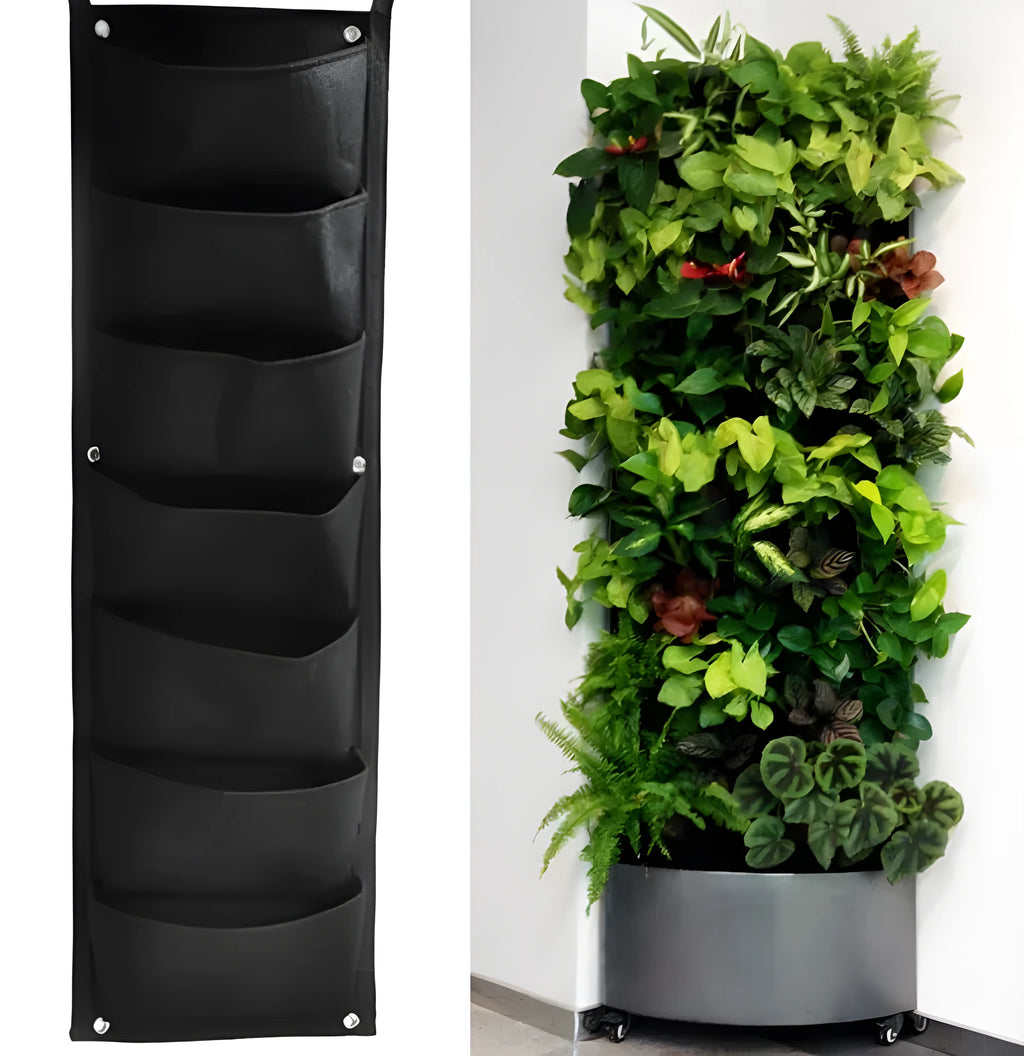 Green vertical felt wall planter with multiple planting pockets hanging on a fence, filled with herbs.