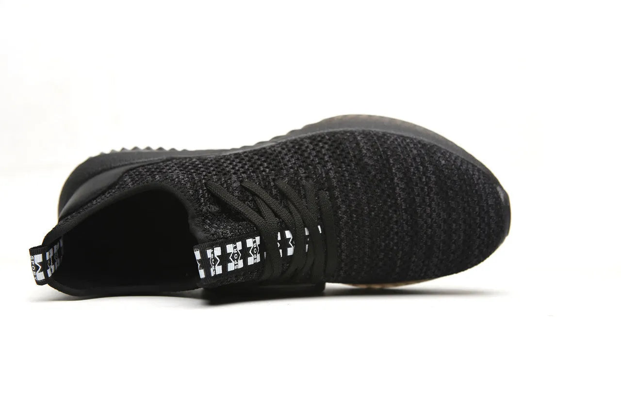 Low-cut black safety shoe with a steel toe cap on a grey background.
