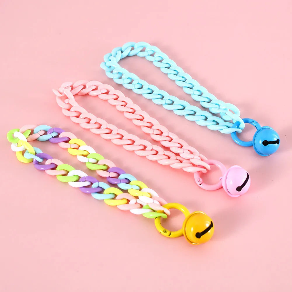 A plastic pet collar in macaron candy colours shown in blue, pink, and mixed variants, with a chain design and S/M size tags.