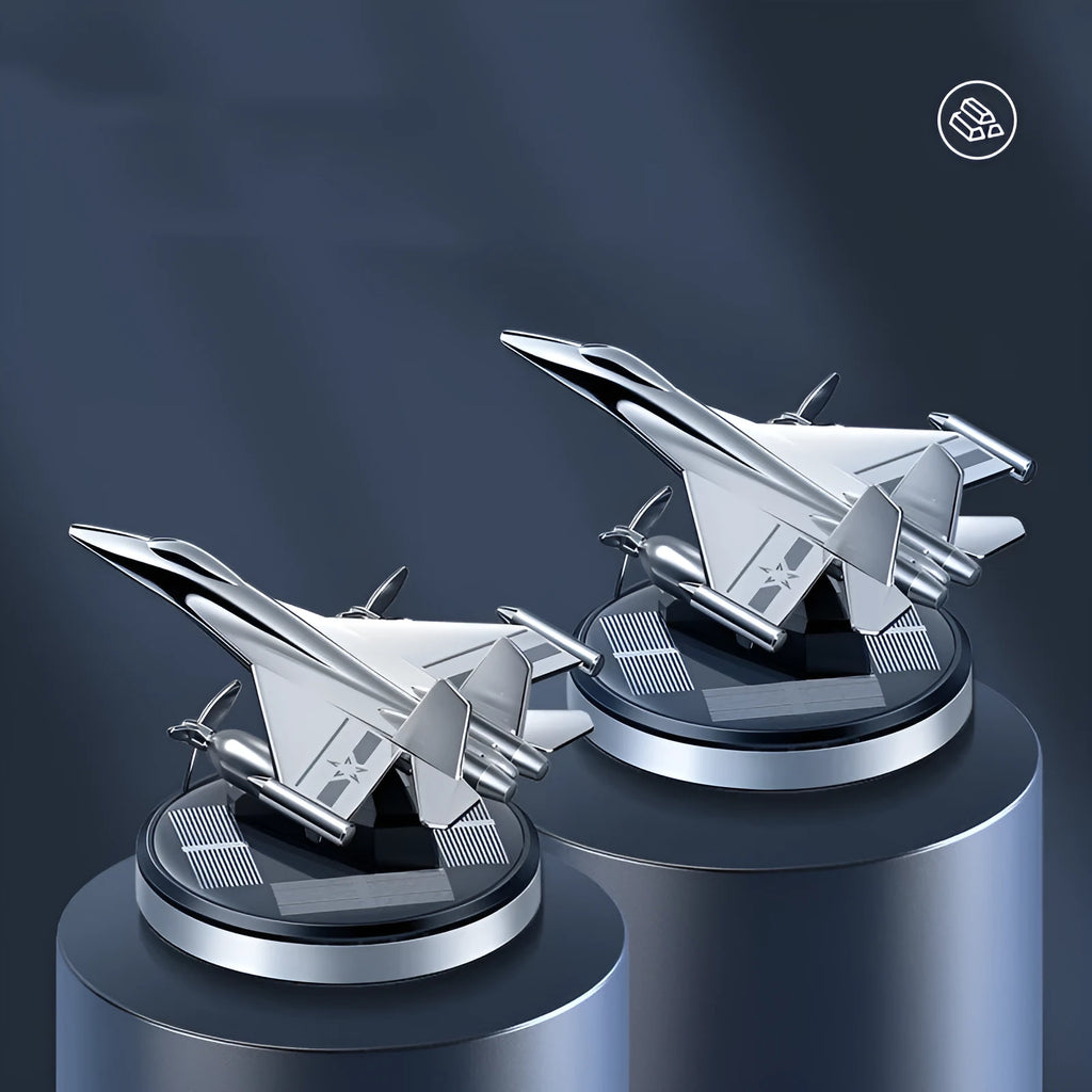 Silver solar-powered rotating fighter jet perfume ornament on a wooden surface.
