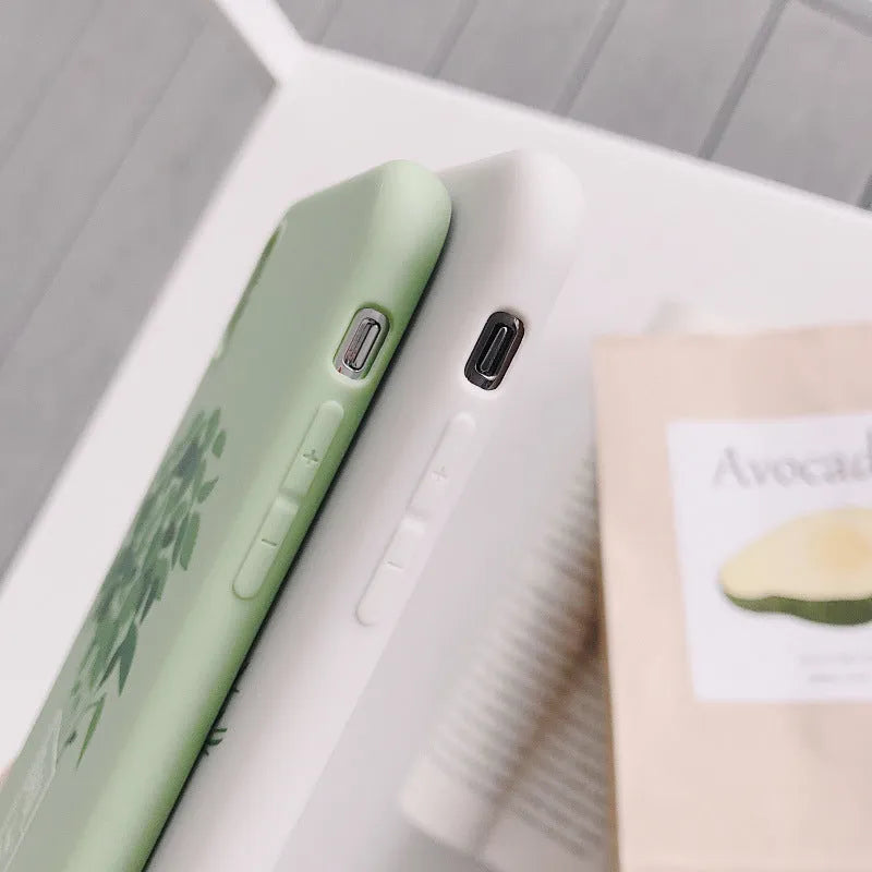White silicone iPhone case with a detailed green plant pattern on the back, showing full device coverage.