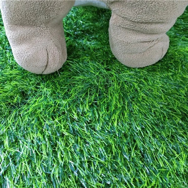 Green washable dog grass pee mat with realistic lawn texture on a patio.