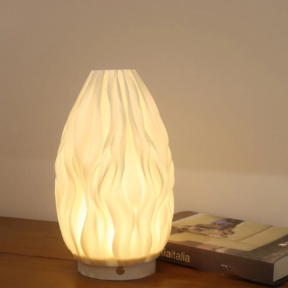 3D printed cylindrical vase night lamp with glass shade in wood colour finish on a bedside table