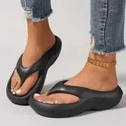 Women's black flip-flops with a thick textured sole and non-slip pattern.