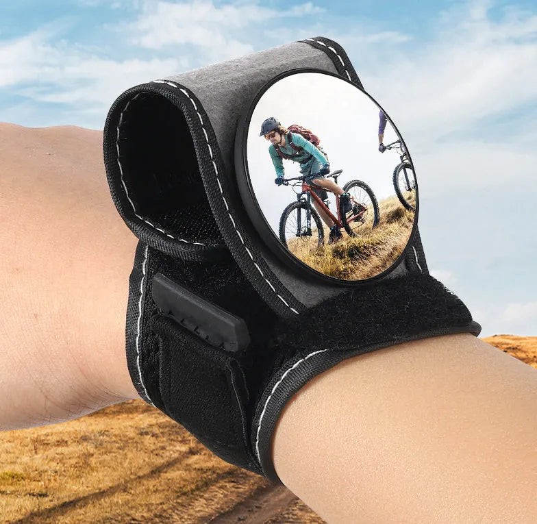 Black nylon cycling wrist rear-view mirror showing strap attachment and mirror positioning