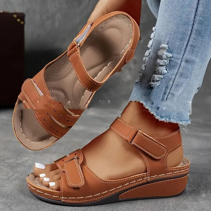 Women's beige strap sandals with a Velcro fastener and thick composite sole, shown in a round toe design.