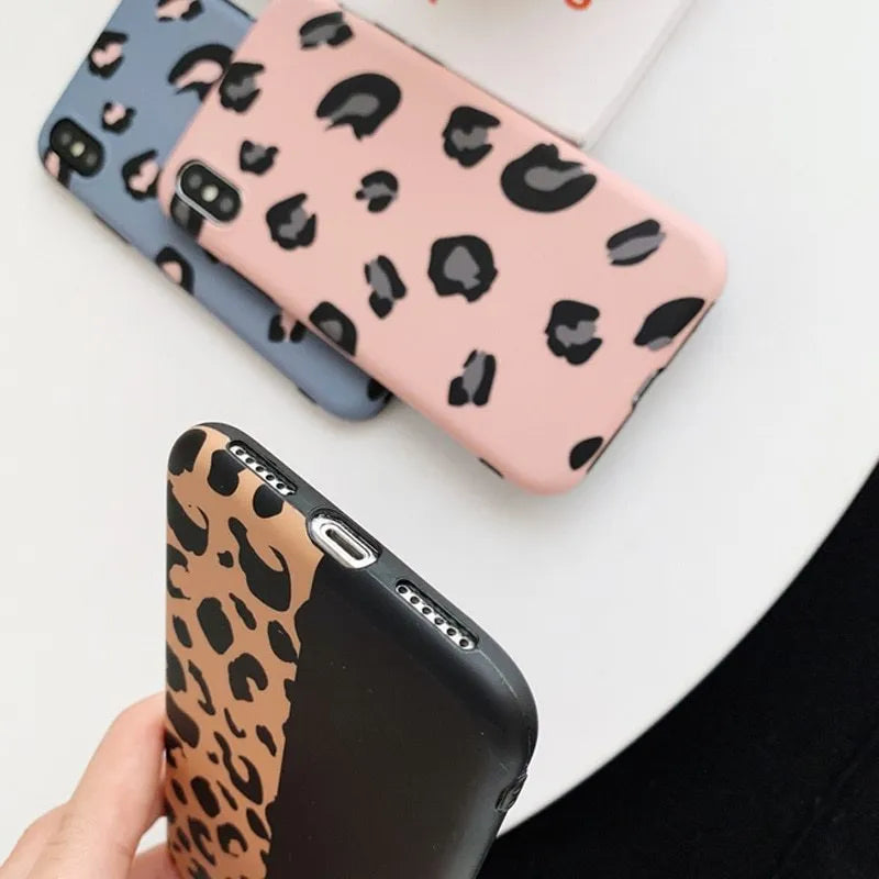 Leopard print pattern phone case for iPhone models on a table.