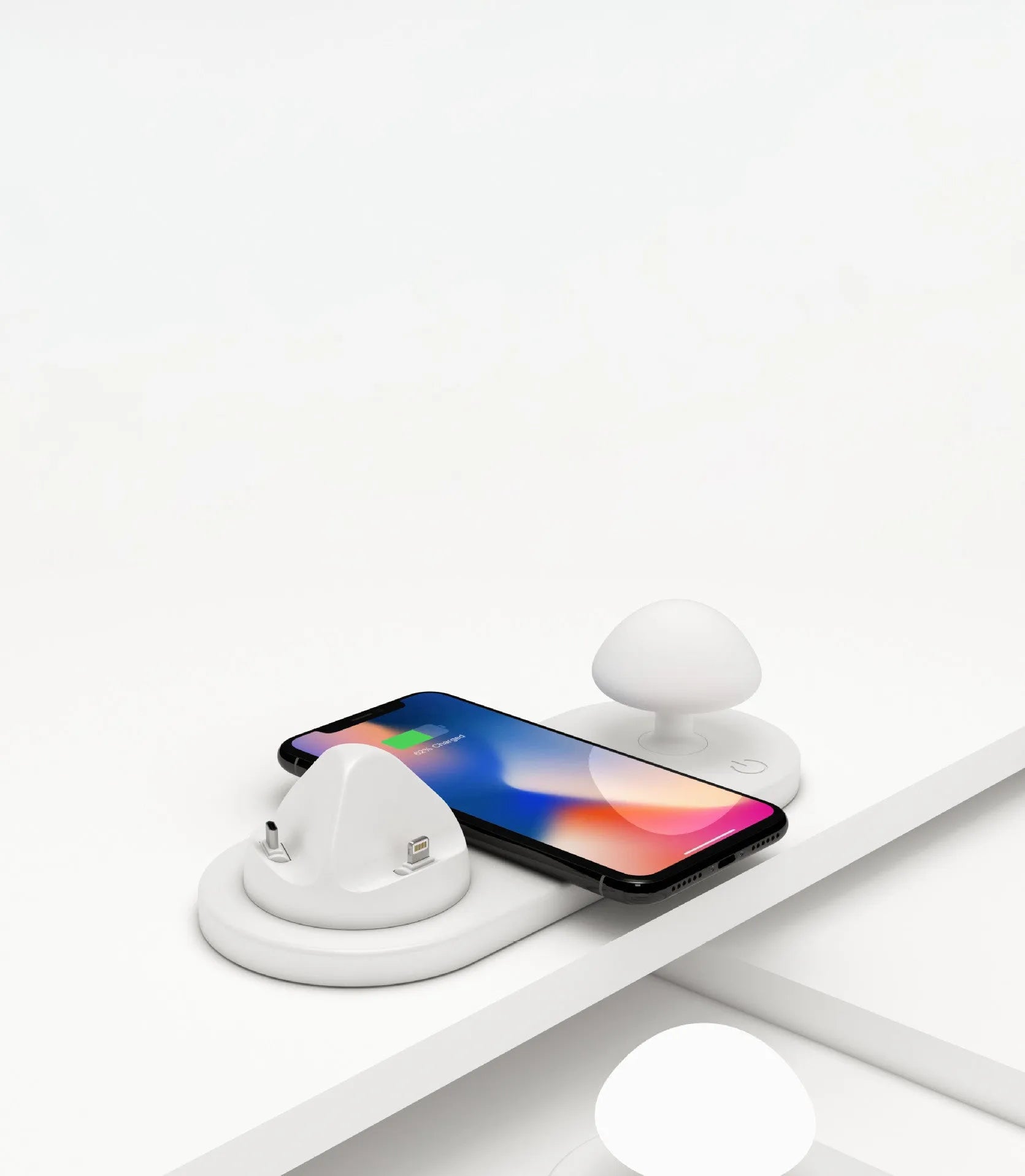White 3 in 1 wireless charging dock with a phone on the pad and USB cable