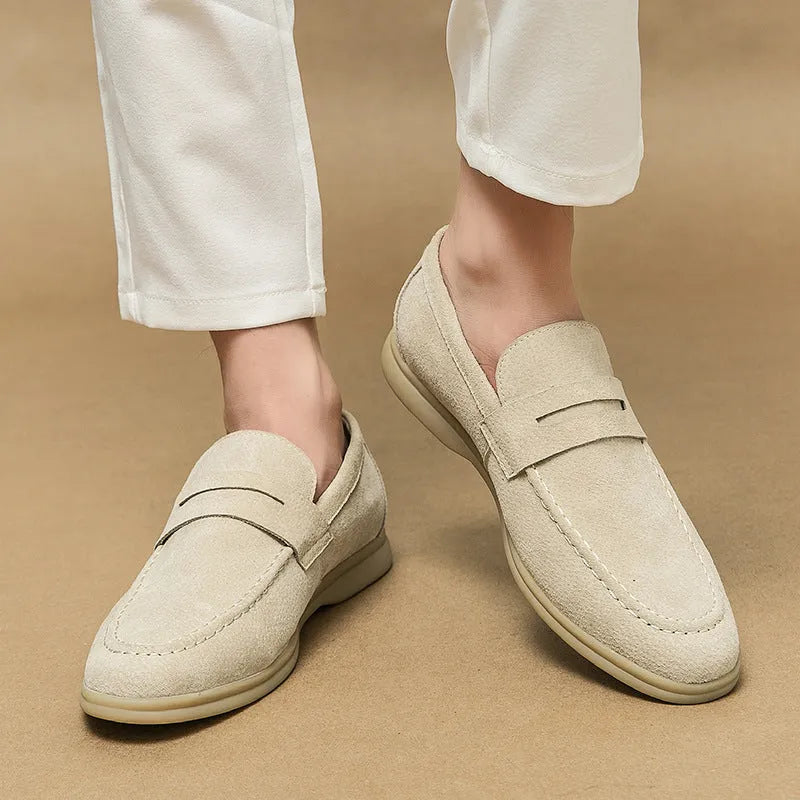 Men's beige leather slip-on casual shoes with round toe and rubber sole on a white background.