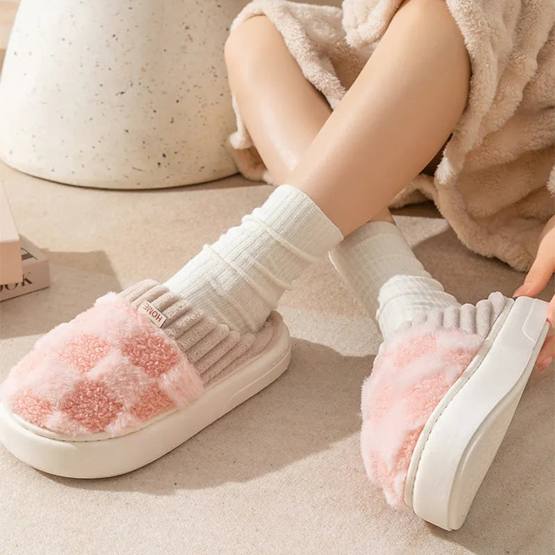 Plaid pattern women's plush slippers with round toe and flat heel on a coloured background.