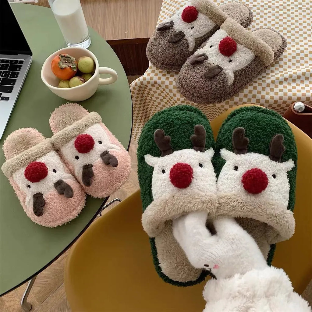 A pair of women's pink cotton slippers with a Christmas deer pattern and a white non-slip PVC sole.