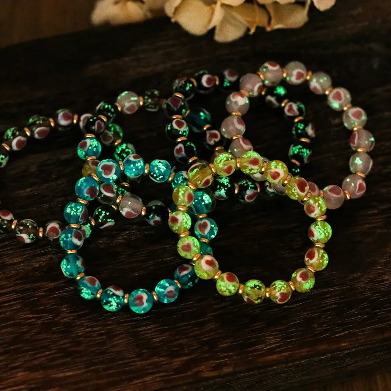 Handmade glass bracelet with swallowing gold beast design and cherry blossom heart in six colours.