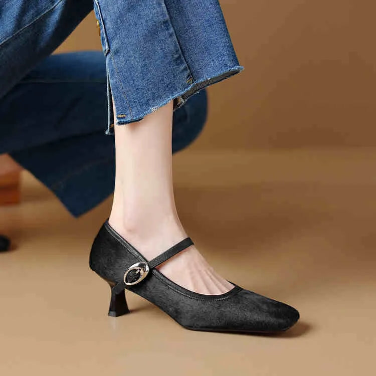 Women's black square toe stiletto heel ankle-strap shoes with horse hair upper on a plain background