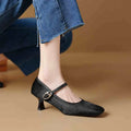 Women's black square toe stiletto heel ankle-strap shoes with horse hair upper on a plain background