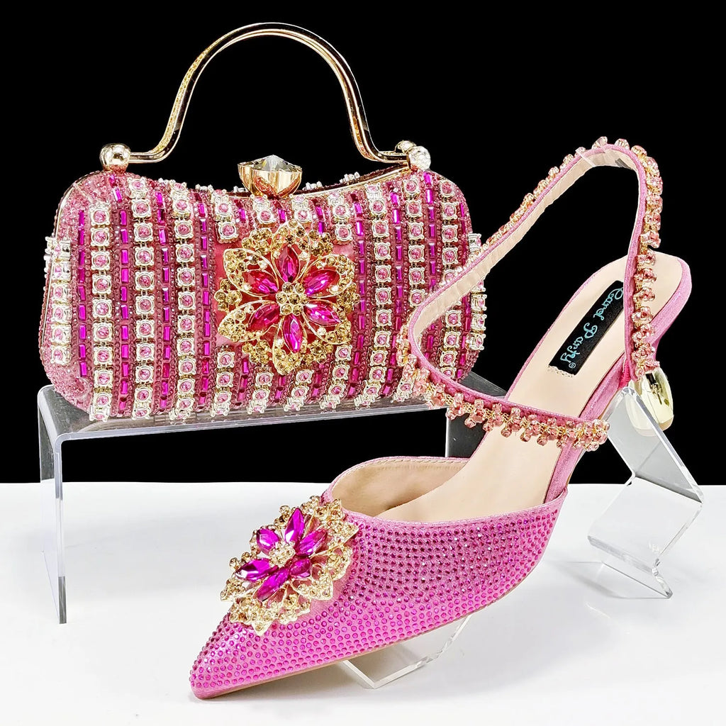 Women's black high heel and matching clutch bag set with floral decoration and rhinestones.