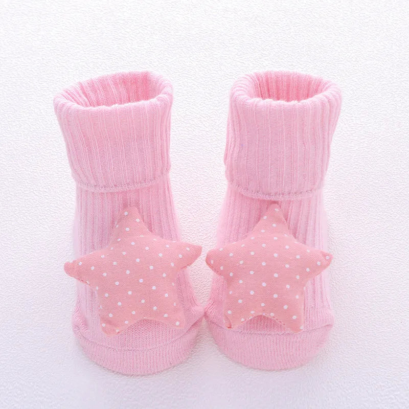 Cotton baby floor socks in a pink bow pattern, shown on an infant's feet.