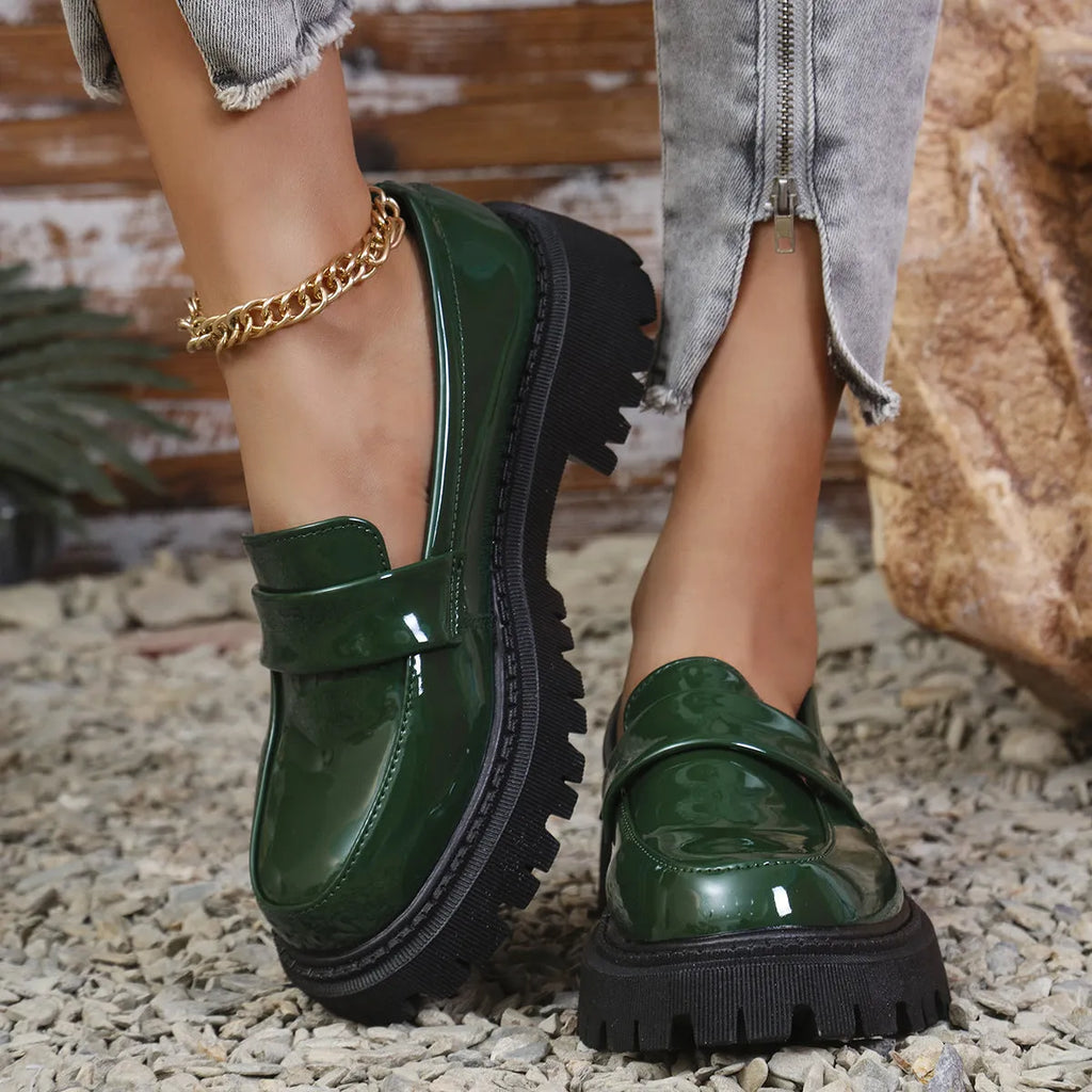 Plus size women's black slip-on loafers with a chunky platform heel and thick rubber sole.
