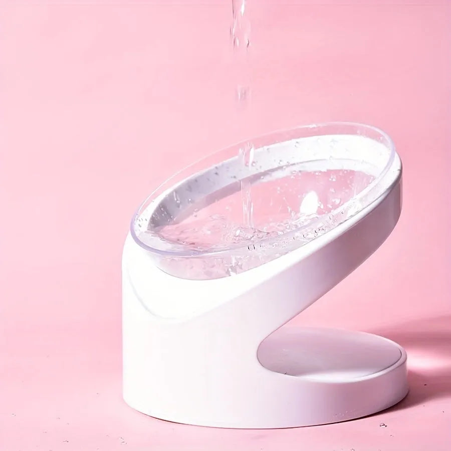 White elevated cat food bowl with a tilted surface on a raised platform.