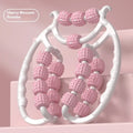 A handheld ring clip leg massage roller with double-row wheels, shown in coral pink.