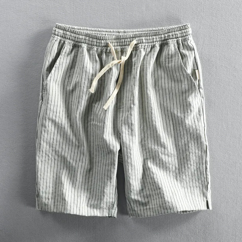 Man wearing striped light grey casual cotton shorts with a straight leg and elastic waistband.