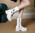 Women's black mid-calf knight boots with a large metal buckle and side zipper detail.