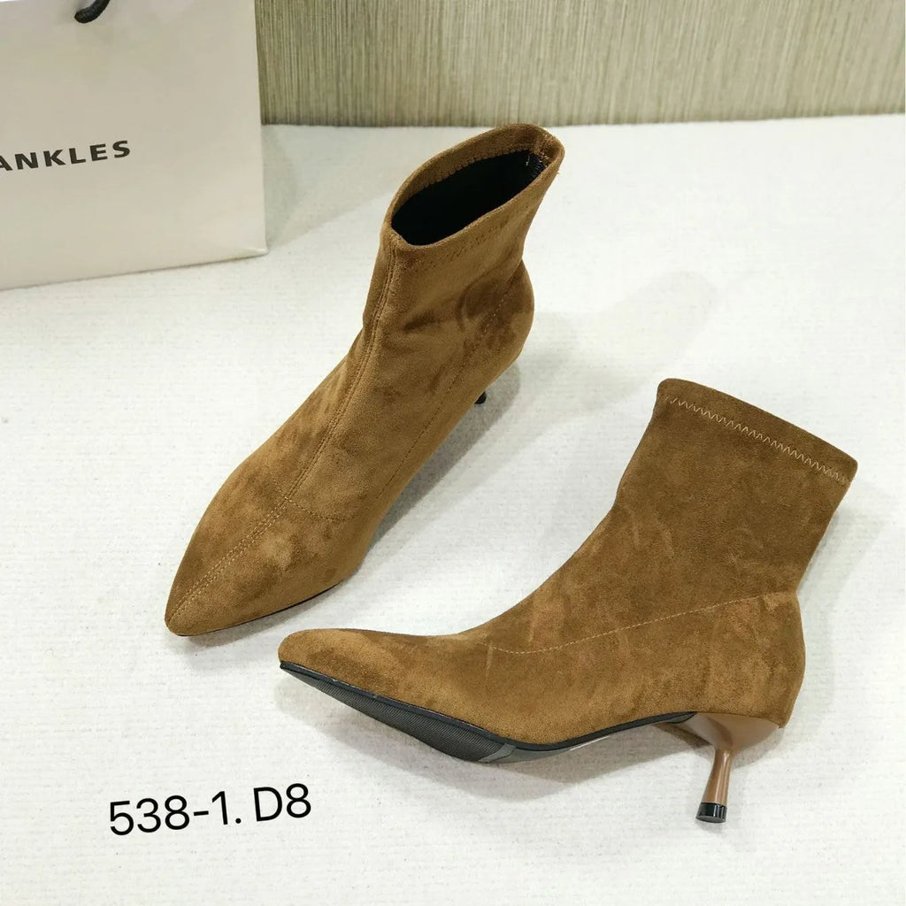 Black pointed toe women's ankle boots with a stiletto heel and mid-calf sock length on a white background