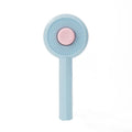 Blue pet grooming brush with angled metal needles and self-cleaning button