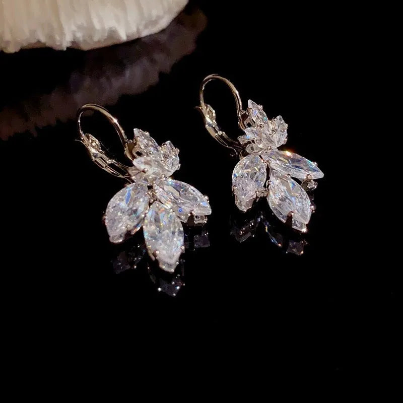 Platinum colour leaf-shaped drop earrings with shiny inlaid zircon details for women.