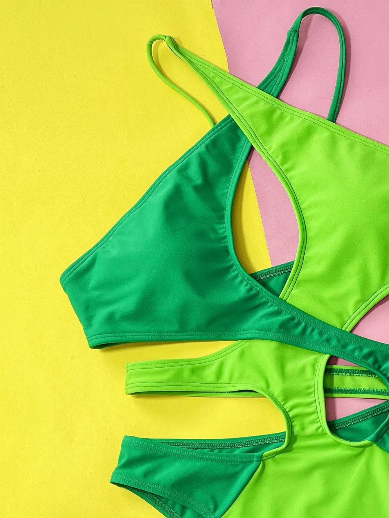 Green solid colour women's one-piece nylon swimsuit on a hanger.