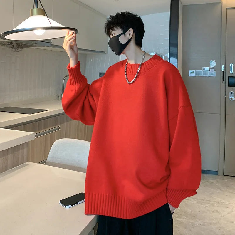 Man wearing a loose fit, solid colour round neck pullover sweater.