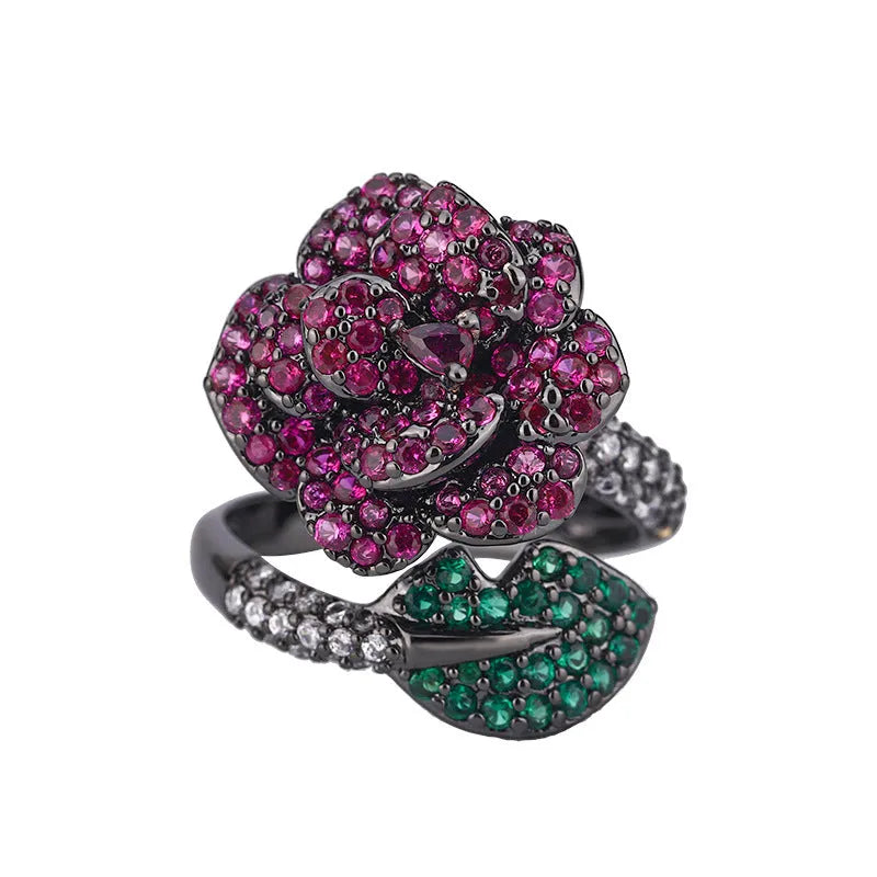 Geometric black gold plated ring with red simulated corundum stone in a floral setting.