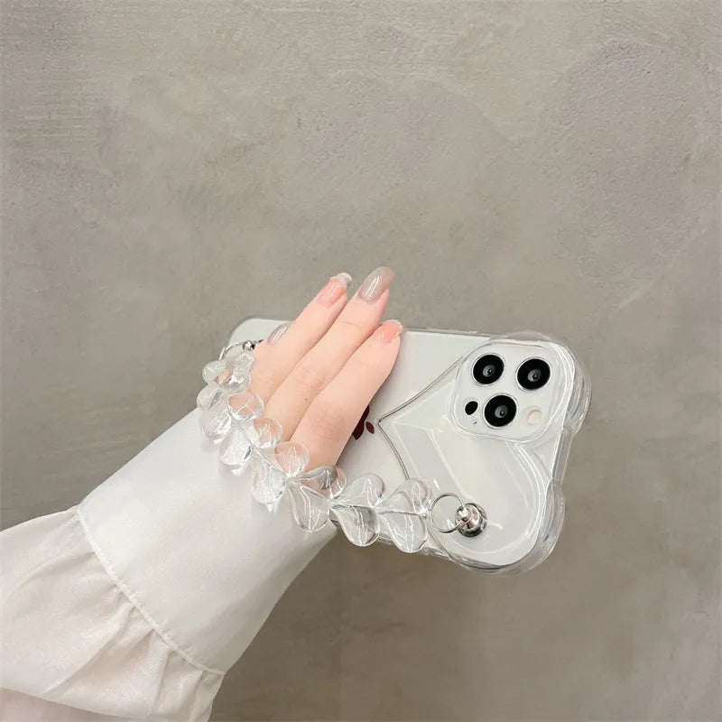 Transparent iPhone case with an attached clear love heart charm bracelet on a TPU shell.
