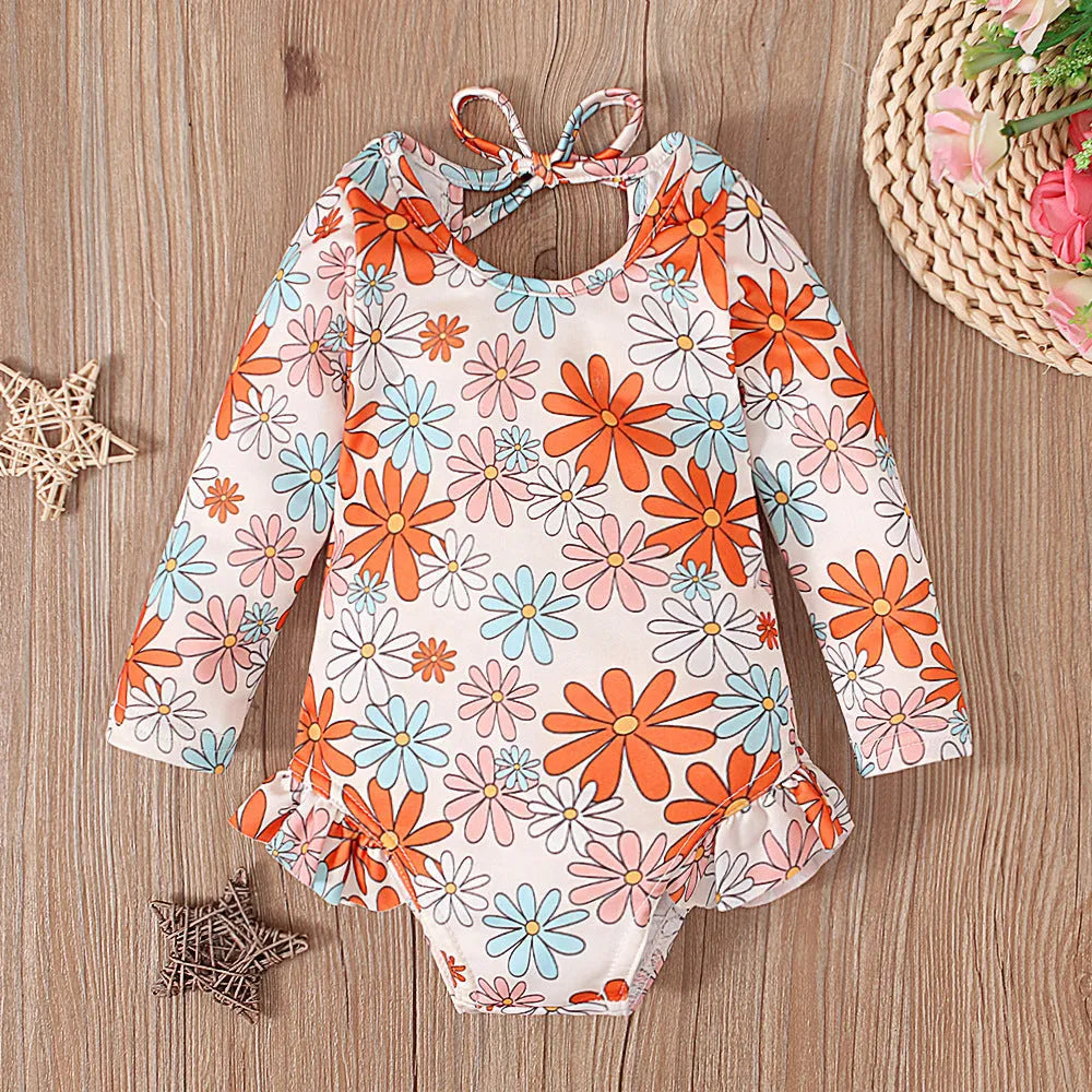 Girl's floral print swimsuit with crew neck and open back in orange red colour.