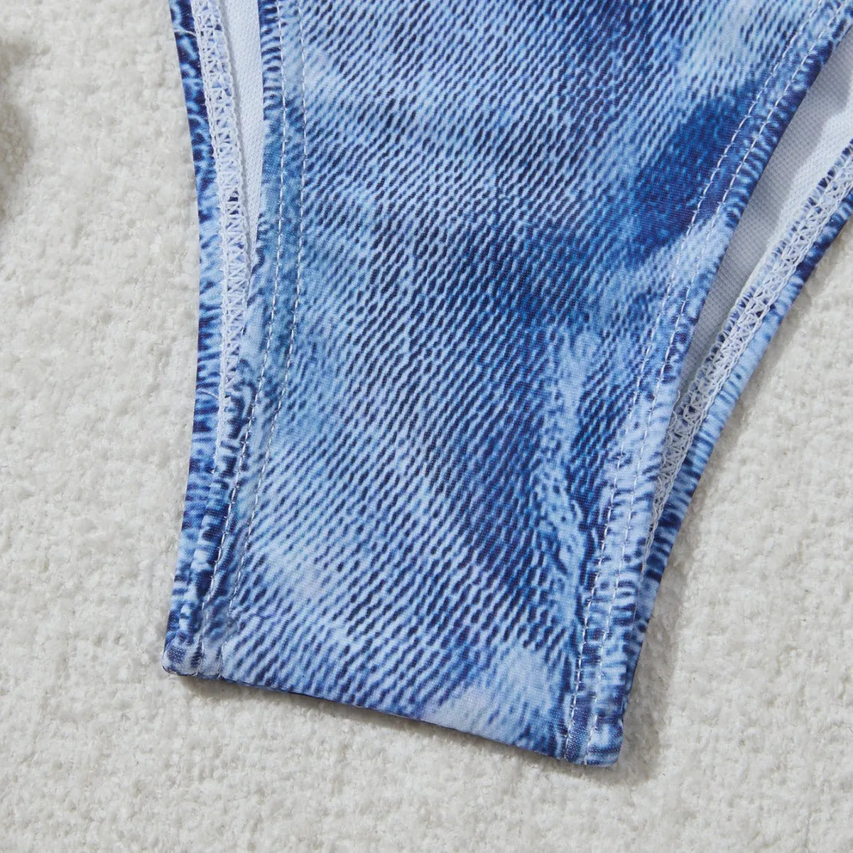 Denim blue printed women's bikini set with strap design on a mannequin, showing top and bottom.