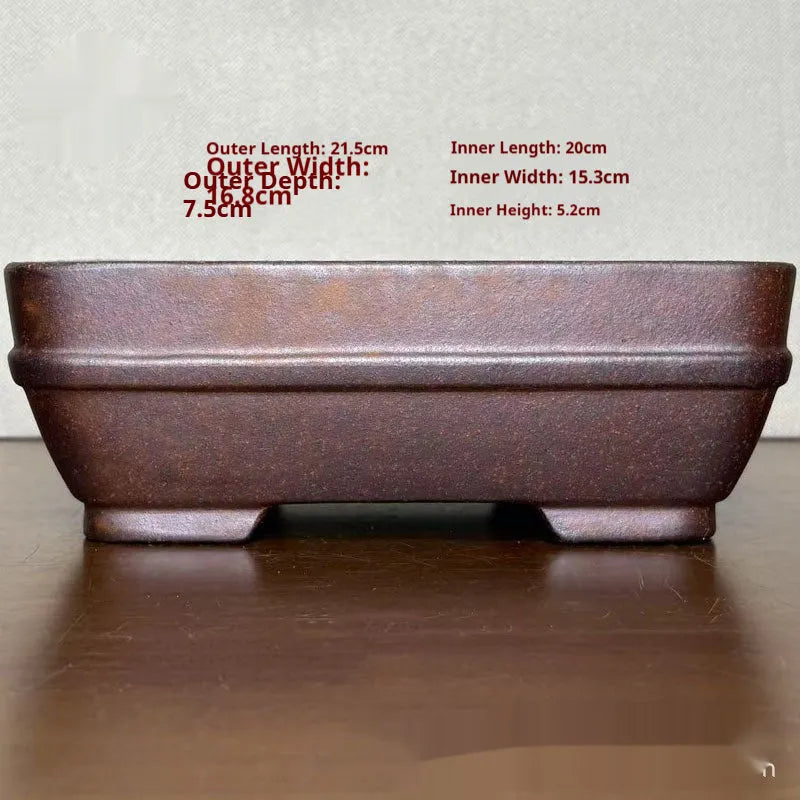 Light brown rectangular ceramic bonsai flower pot on a wooden surface