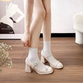 Women's black patent leather round toe chunky heels with a buckle strap, shown in a widened fit style.