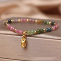 Natural tourmaline beaded floral anklet shown as adjustable bracelet on woman's wrist