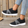 Black women's flat shoes with flyknit mesh upper, round toe, tassel detail, and flat rubber sole.