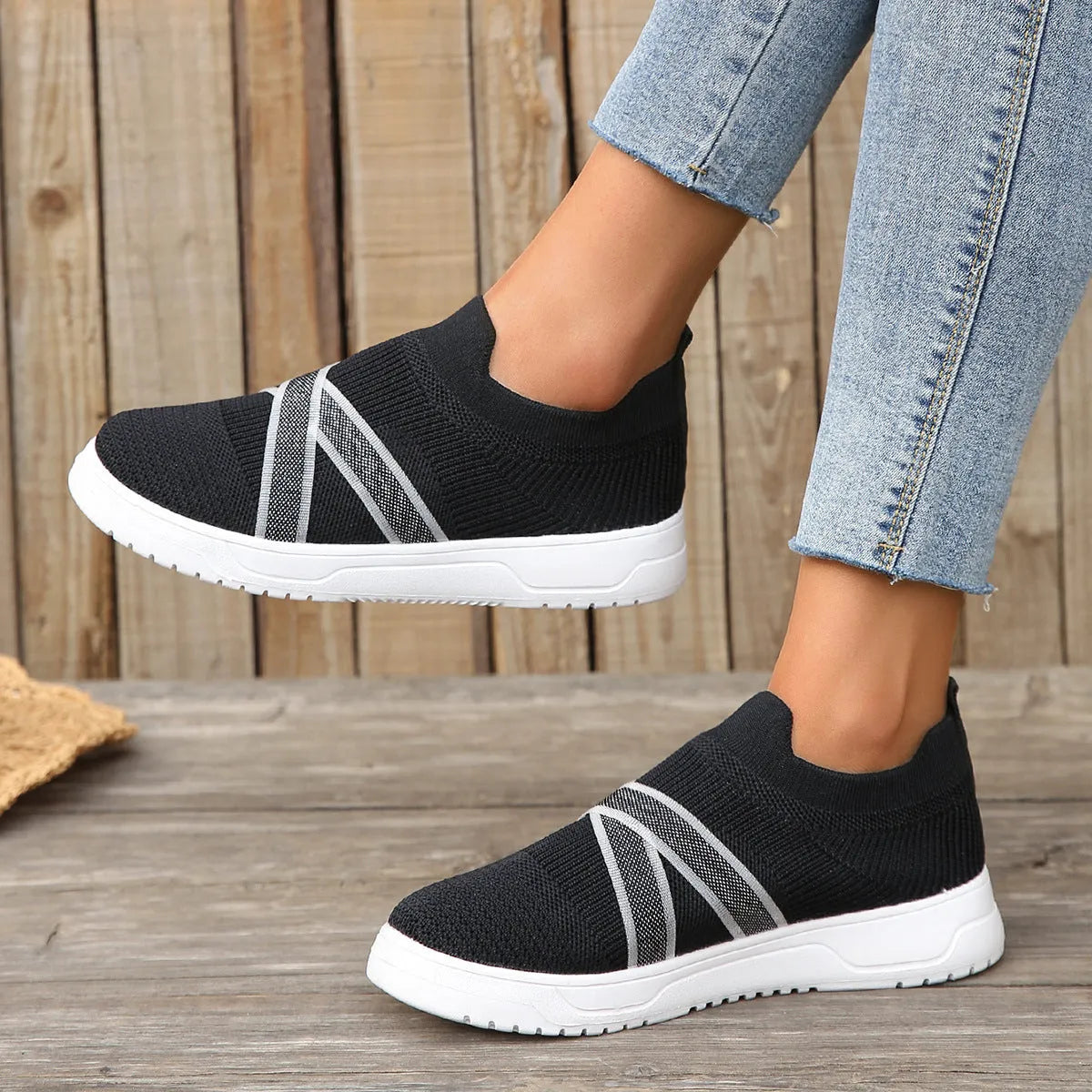 Black women's flat shoes with flyknit mesh upper, round toe, tassel detail, and flat rubber sole.