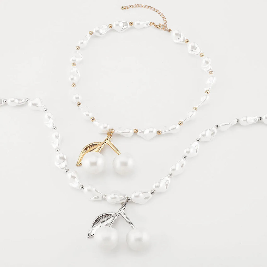 Women's gold and white necklace with cherry fruit and pearl pendant on an adjustable chain