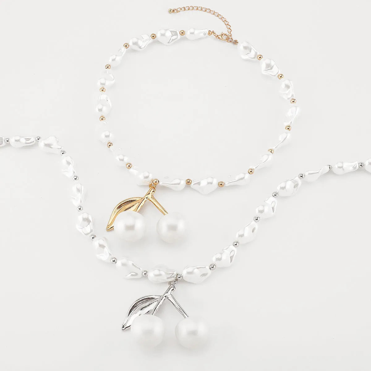 Women's gold and white necklace with cherry fruit and pearl pendant on an adjustable chain