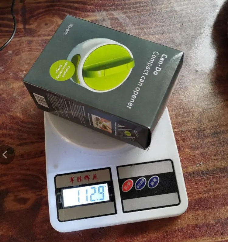 Green stainless steel bottle opener gadget for screw-top lids on a kitchen counter.