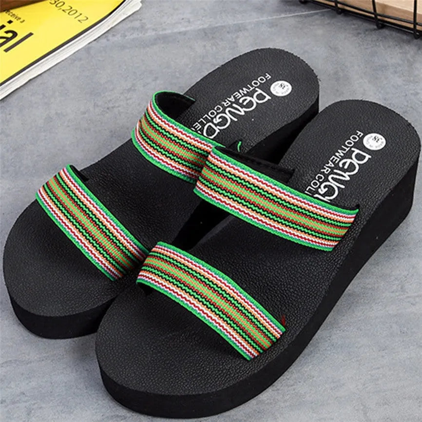Women's brown bohemian summer slippers with elastic strap and rubber sole on a sandy beach.