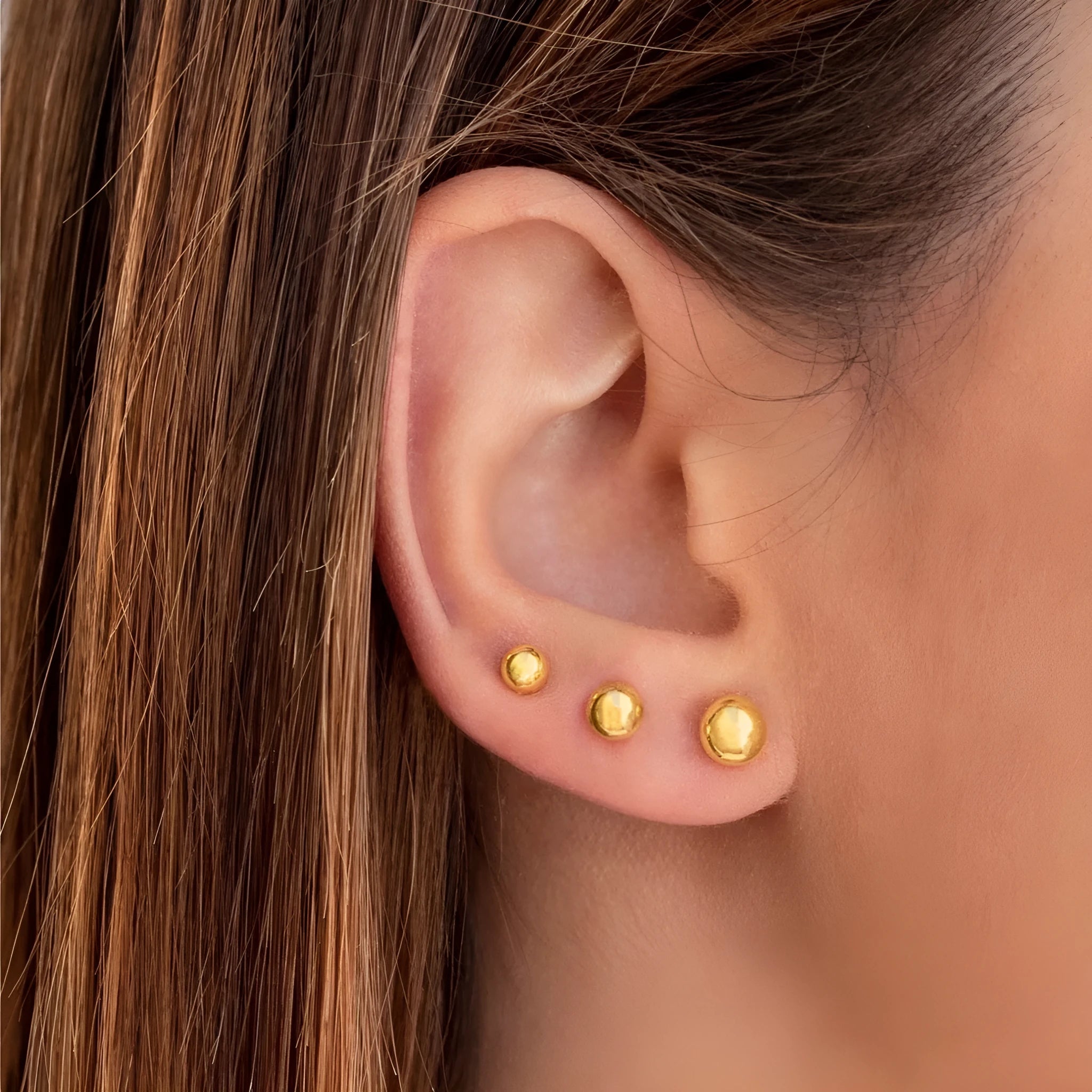 Minimalist round ball stud earrings in gold and silver finishes, showing different size options on a plain background.