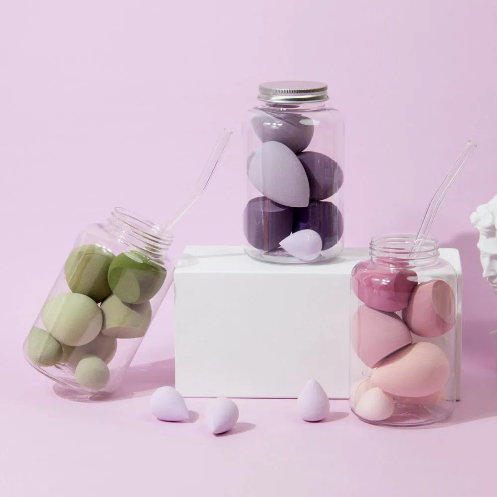 Set of 7 colourful makeup sponge eggs in a transparent jar against a white background