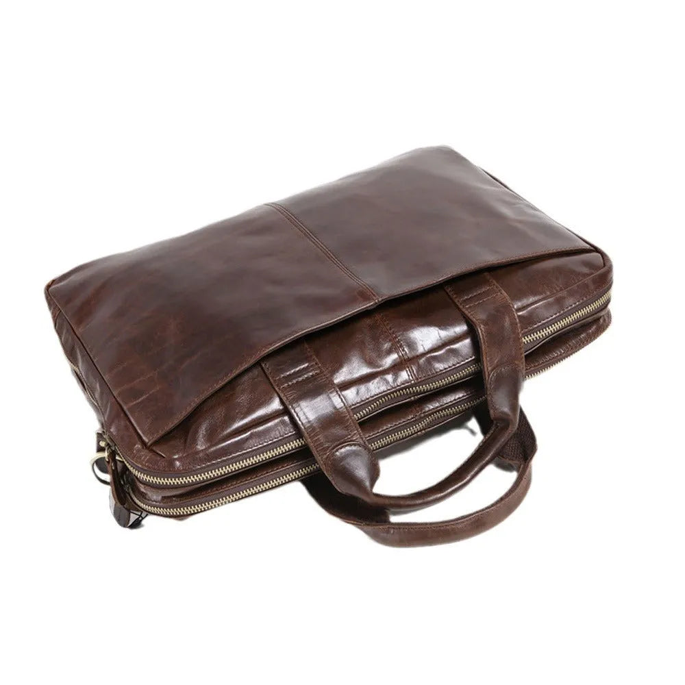 Brown cowhide leather business briefcase open showing interior polyester cotton lining and 18-inch laptop storage