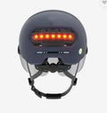 Cycling helmet with integrated LED front light and red tail light on a black PC shell.